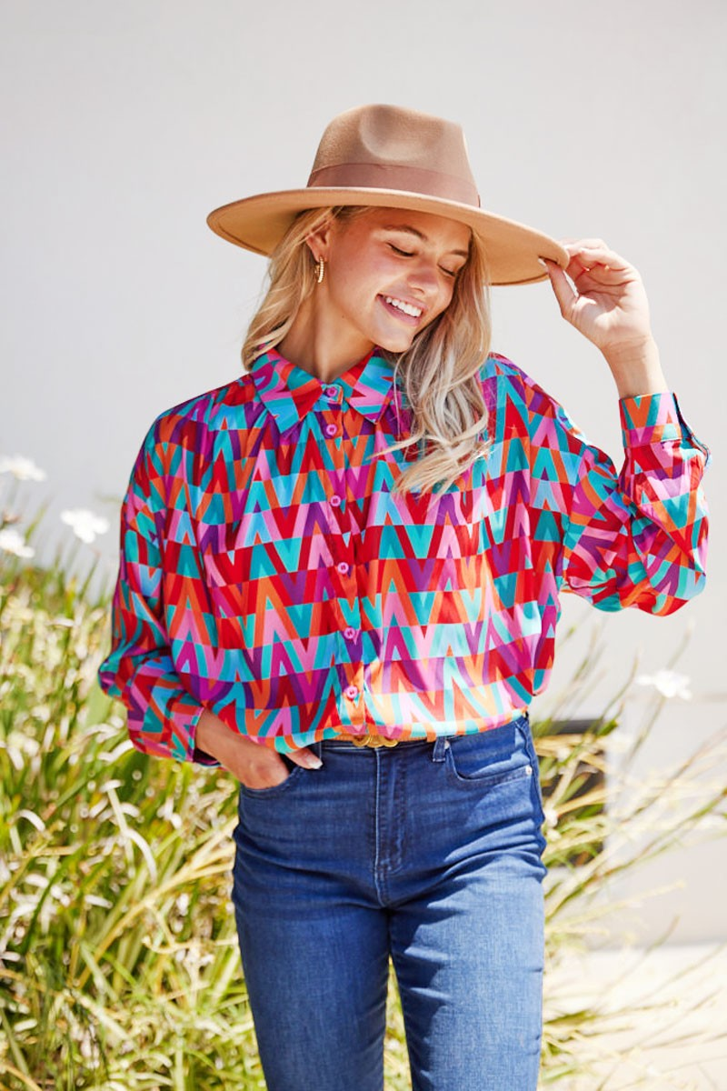 Fashionable geometric pattern collared blouse featuring a slight puffed shoulder and button-up long sleeves. Unlined and airy.